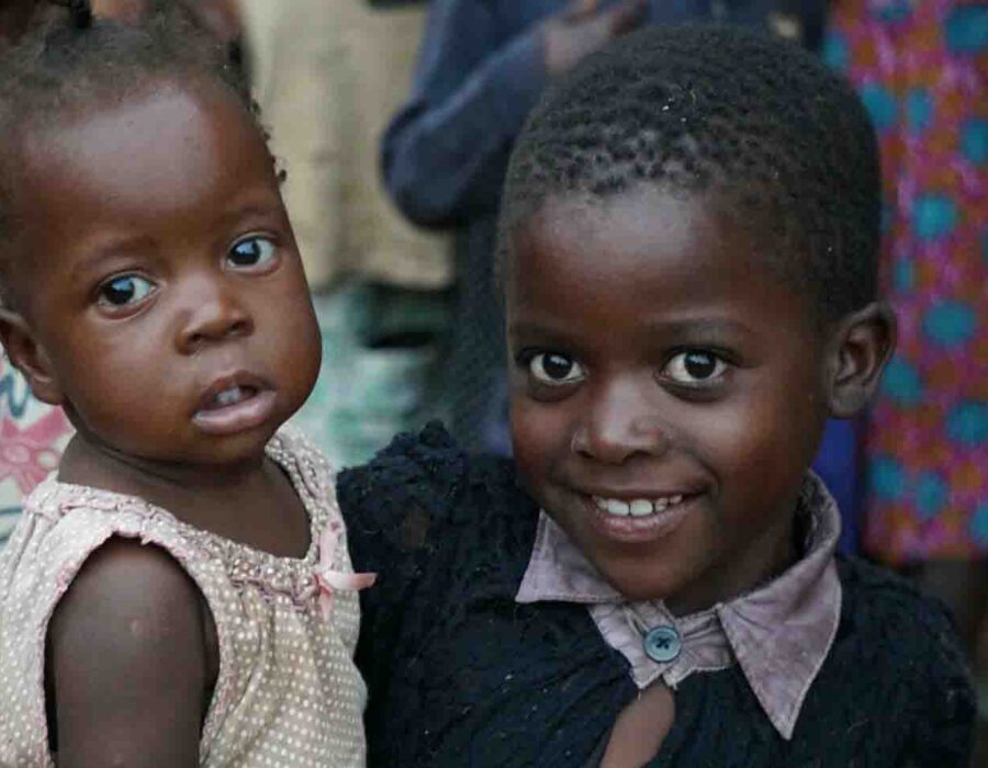 A girl carries her sibling during the lockdown. Children in efiug communities are left to take care of their siblings.